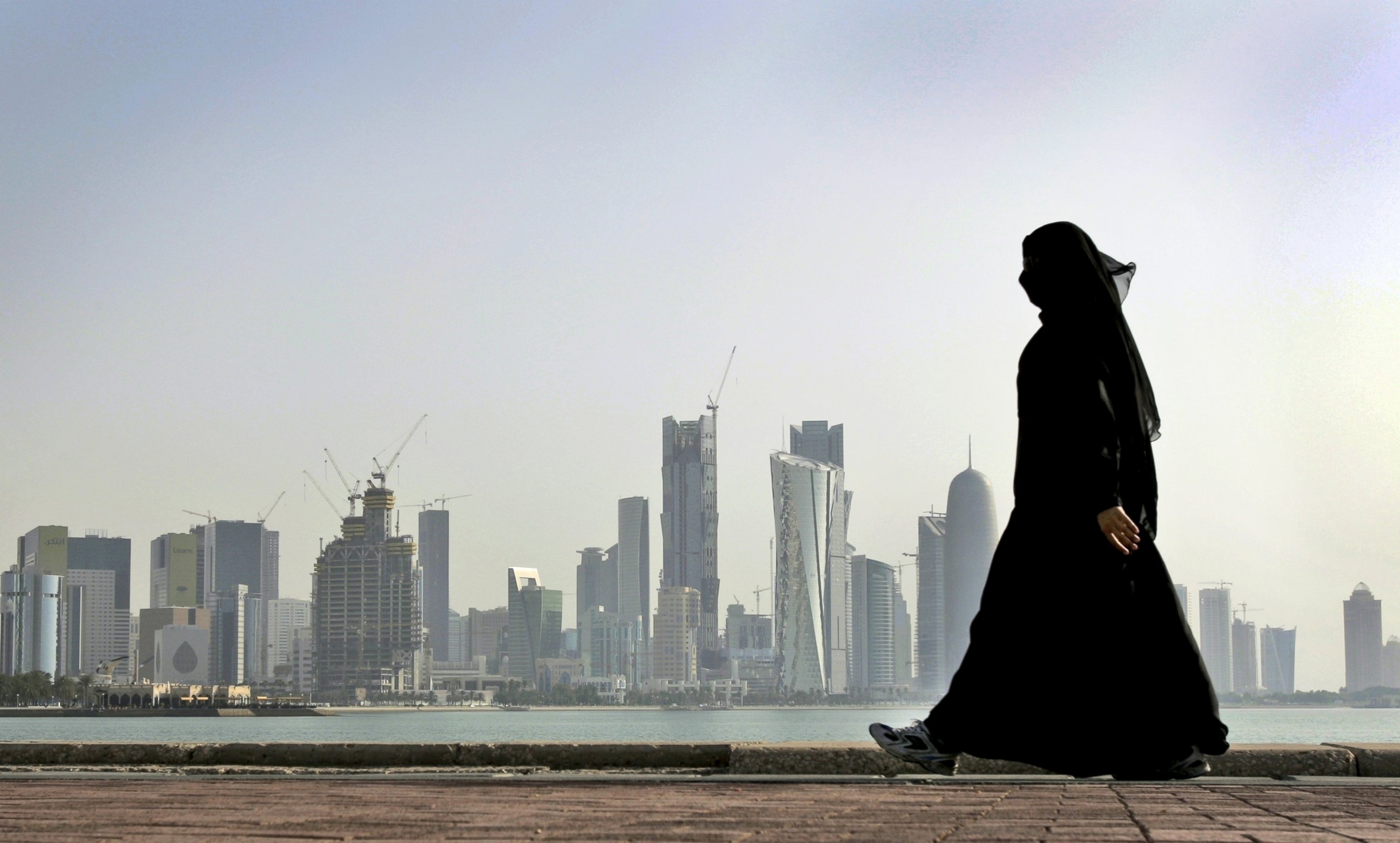 PHOTO: A Qatari woman walks in front of the city skyline in Doha, Qatar, May 14, 2010, file photo.