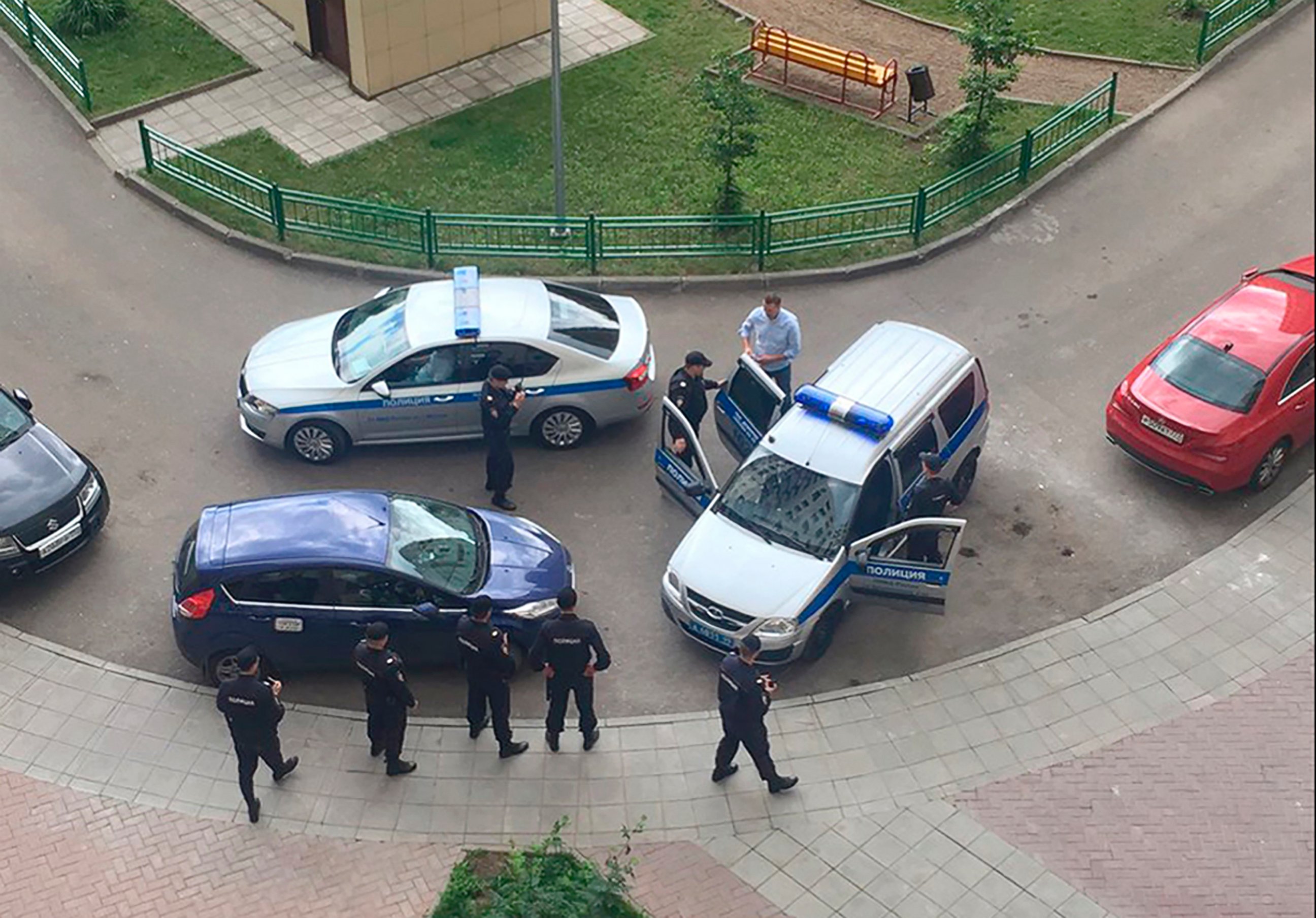PHOTO: Alexei Navalny, blue shirt, is detained by police outside his apartment in Moscow, June 12, 2017.

