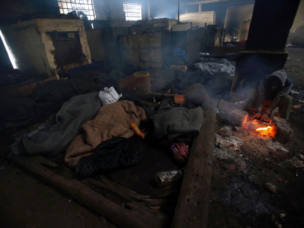 PHOTO: A migrant tries to warm up by a fire inside a crumbling warehouse that has served as a make-shift shelter for hundreds of men trying to reach Western Europe in Belgrade, Serbia, Jan. 12, 2017.