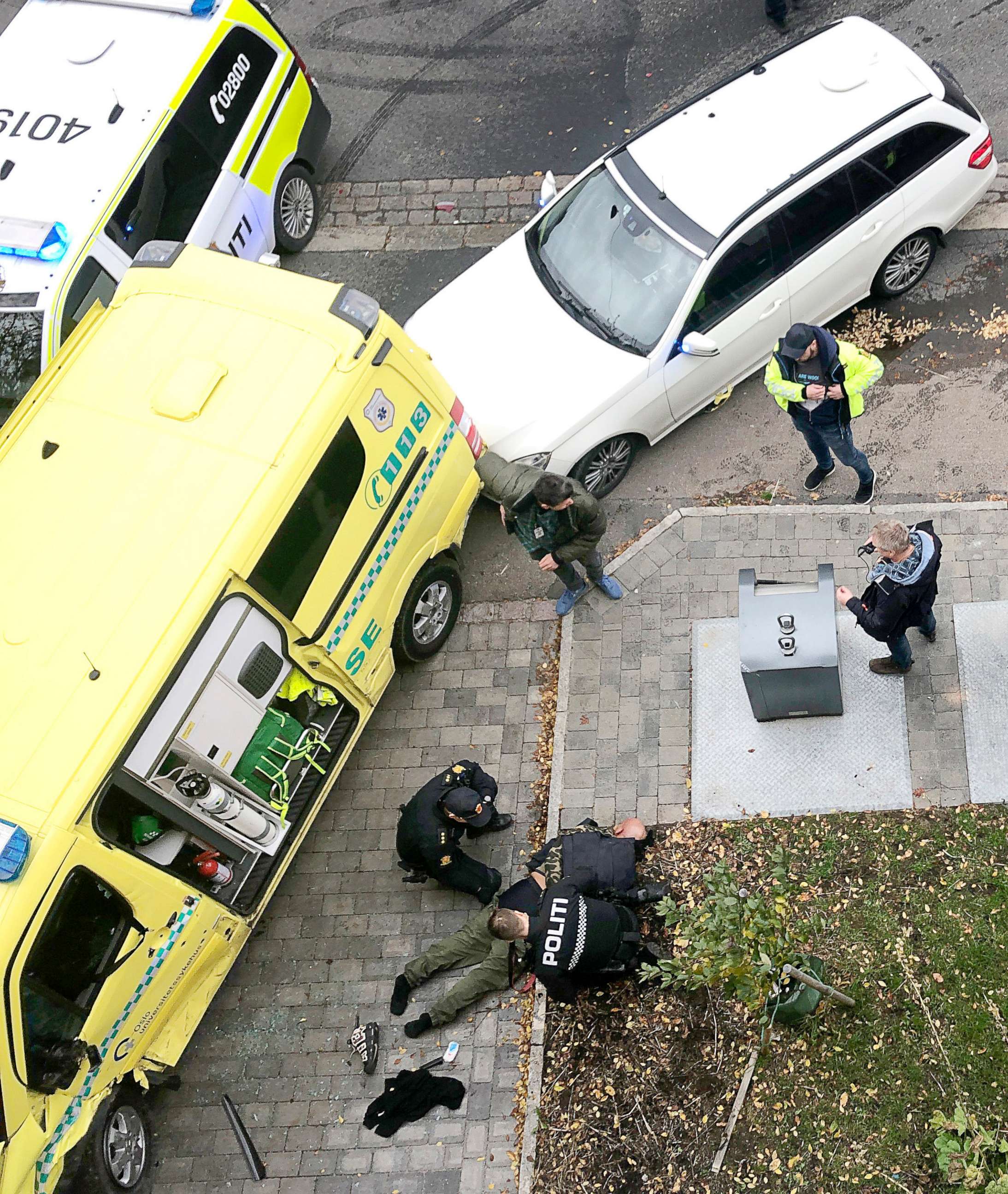 PHOTO: Police detain a man, bottom center laying on the ground, next to a damaged ambulance that he stole after an incident in the center of Oslo, Tuesday, Oct. 22, 2019. (Cathrine Hellesoy, Aftenposten via AP) 