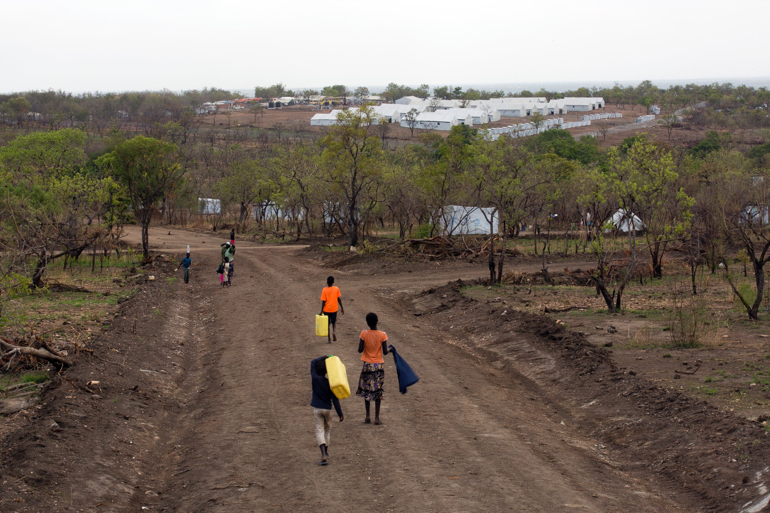 PHOTO: In this Thursday, April 6, 2017 photo, South Sudanese children carry water jugs down a road in the new Imvepi refugee settlement in northern Uganda.