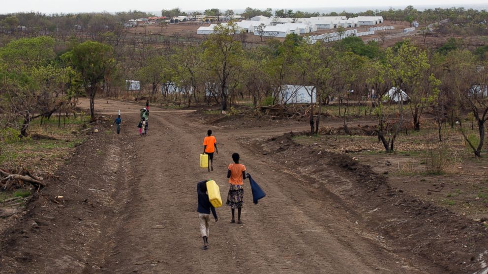 PHOTO: In this Thursday, April 6, 2017 photo, South Sudanese children carry water jugs down a road in the new Imvepi refugee settlement in northern Uganda.