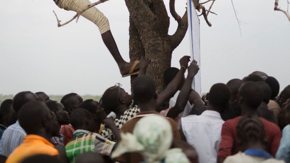PHOTO: In this Monday, April 3, 2017 photo in the Imvepi camp, South Sudanese refugees gather under a tree from which names are announced for those allocated a land parcel from the Ugandan government.