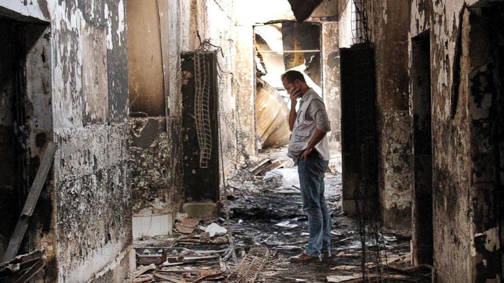 In this Oct. 16, 2015, file photo, an employee of Doctors Without Borders walks inside the charred remains of the organization's hospital after it was hit by a U.S. airstrike in Kunduz, Afghanistan. 