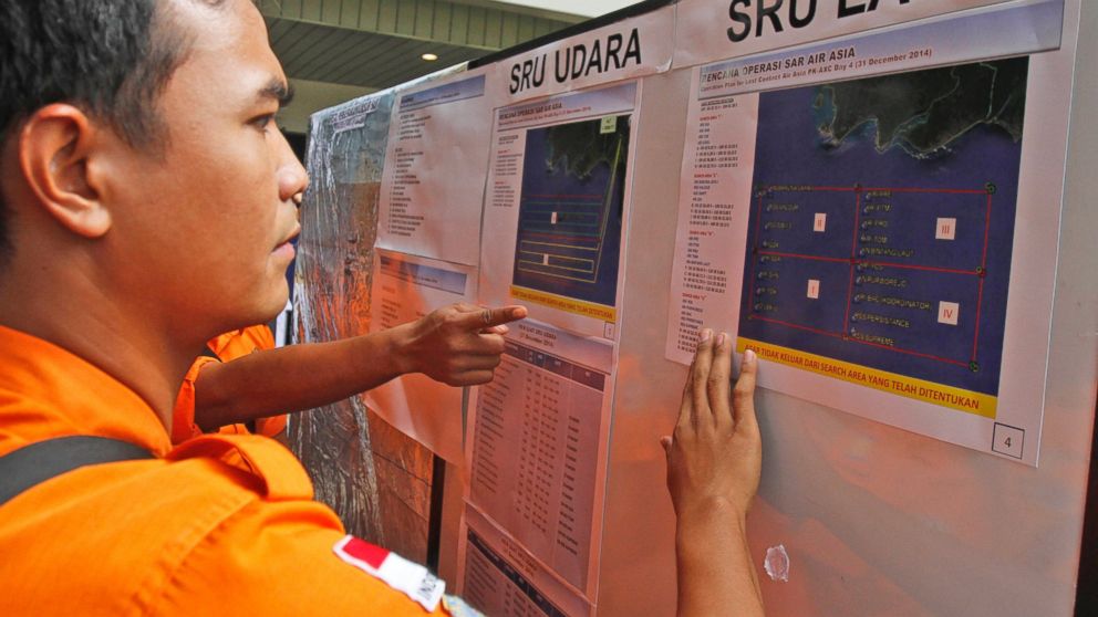 Officers of the National Search And Rescue Agency (BASARNAS) examine maps of the area where the debris and bodies from AirAsia flight 8501 were found, at the crisis center at Juanda International Airport in Surabaya, East Java, Indonesia, Dec. 31, 2014.