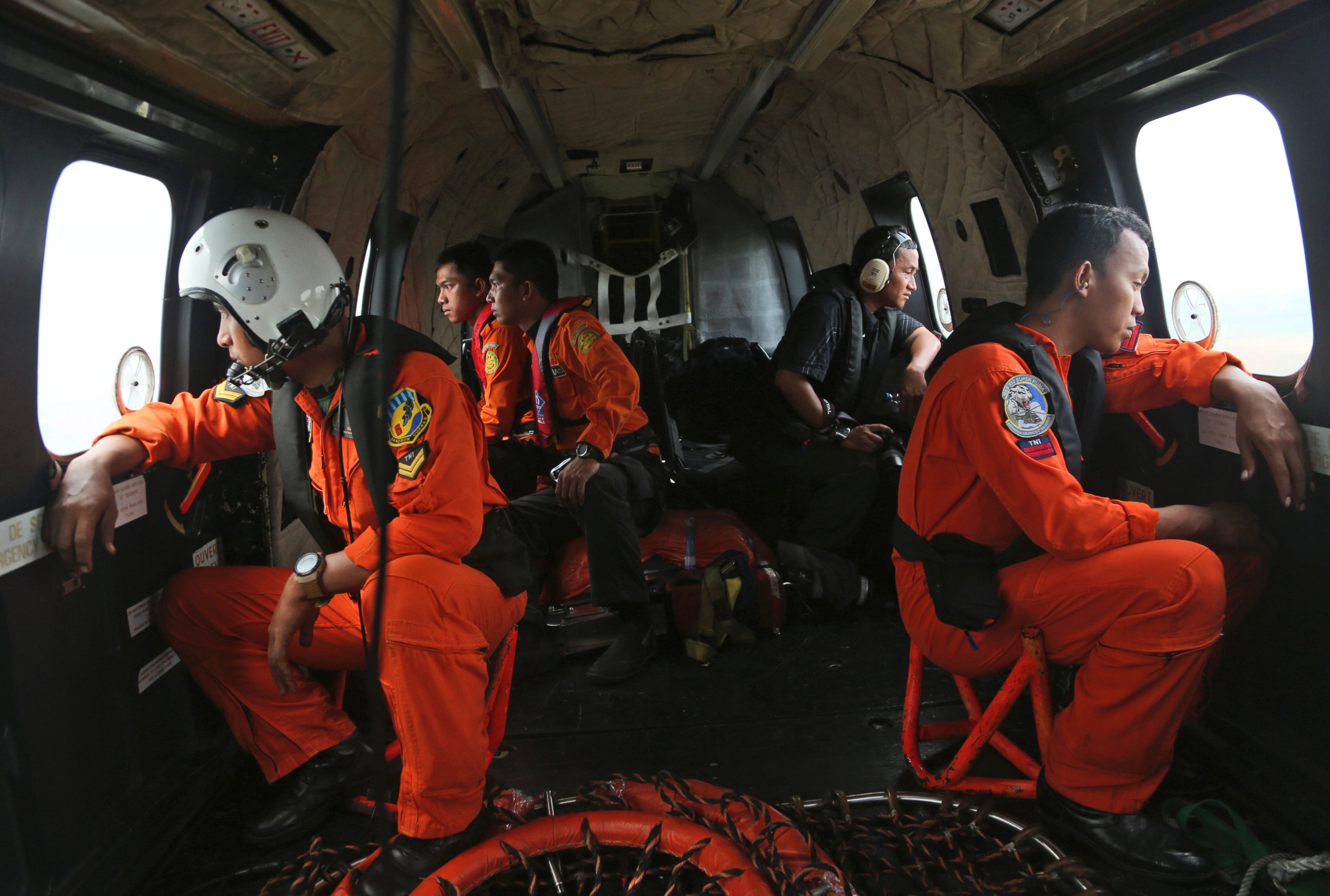 PHOTO: Crewmembers of Indonesian Air Force NAS 332 Super Puma helicopter look out of the windows during a search operation for the victims and wreckage of AirAsia Flight QZ 8501 over the Java Sea, Indonesia, Jan. 5, 2015.
