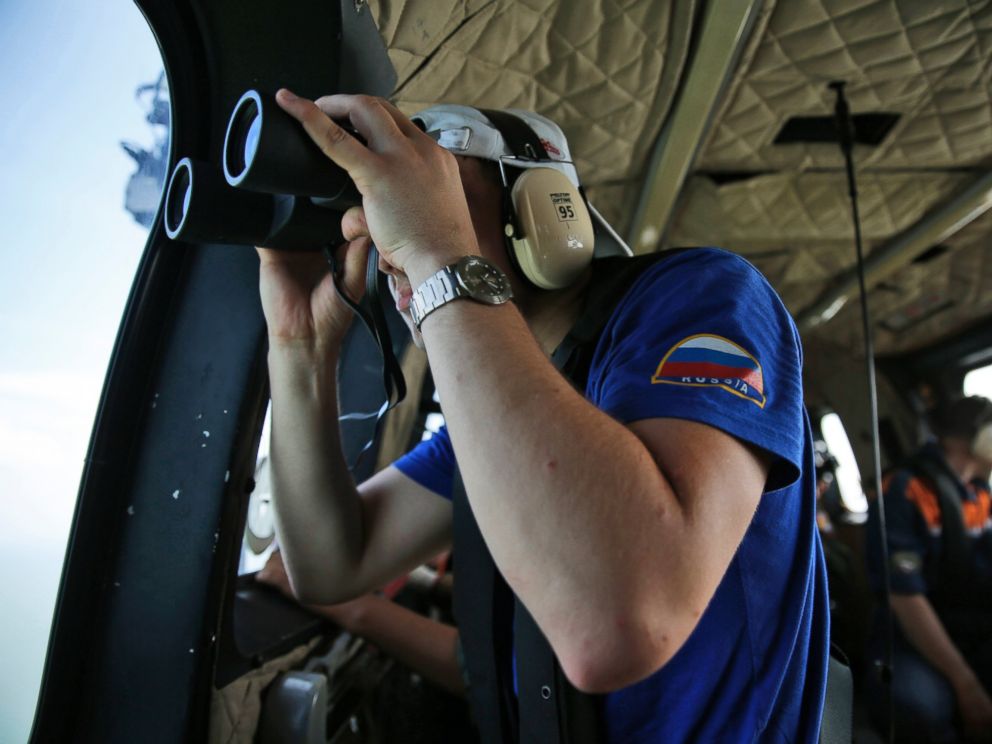 PHOTO: A member of Russian rescue team uses his binoculars during a search operation for the victims of AirAsia Flight 8501 on an Indonesian Air Force Super Puma helicopter over the Java Sea, Indonesia, Jan. 7, 2015.