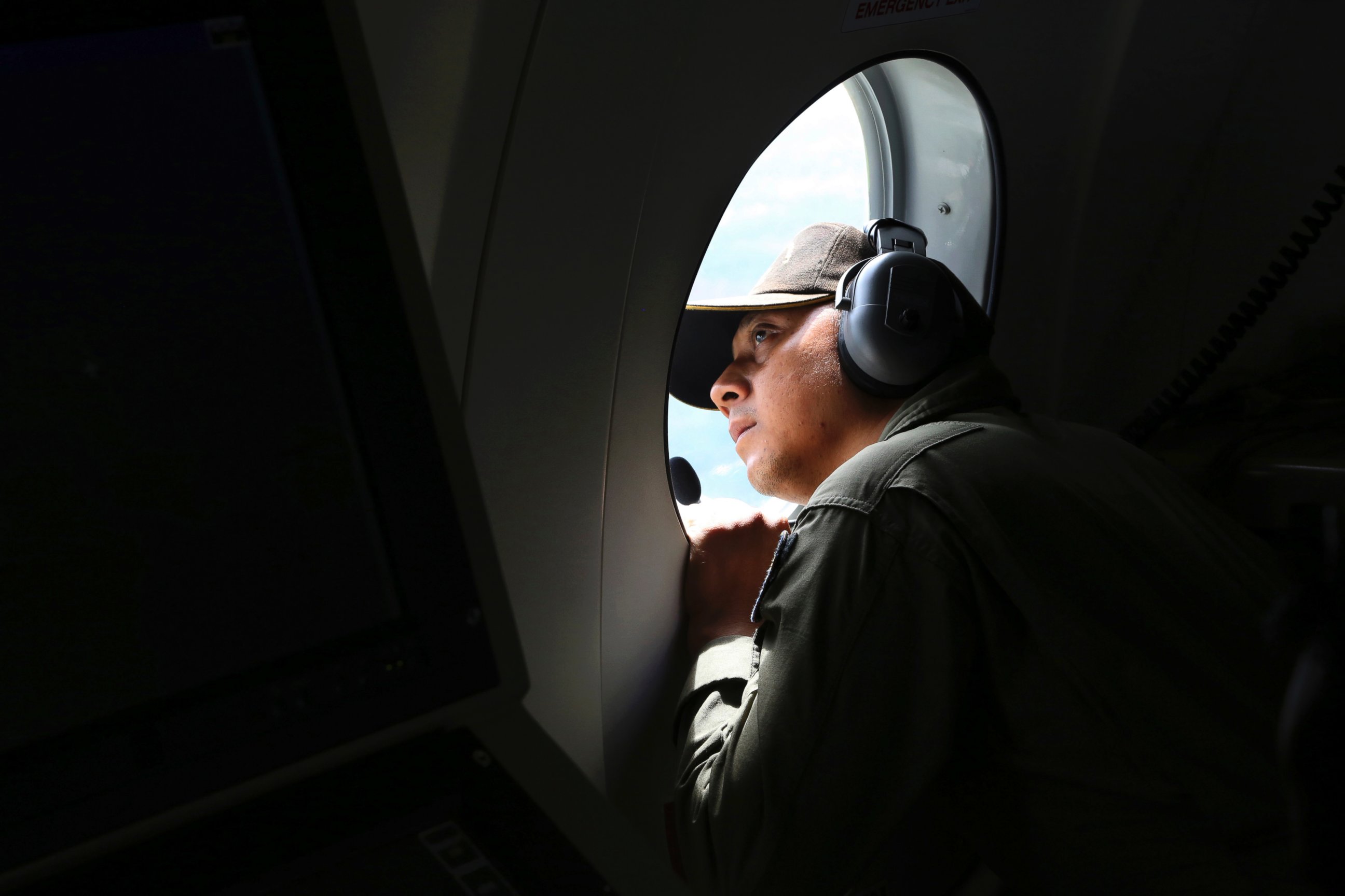PHOTO: A crew member of Indonesian Navy CN-235 airplane looks out of the window during a search operation for the missing AirAsia flight 8501 over the waters off Bangka Island, Indonesia, Dec. 30, 2014.