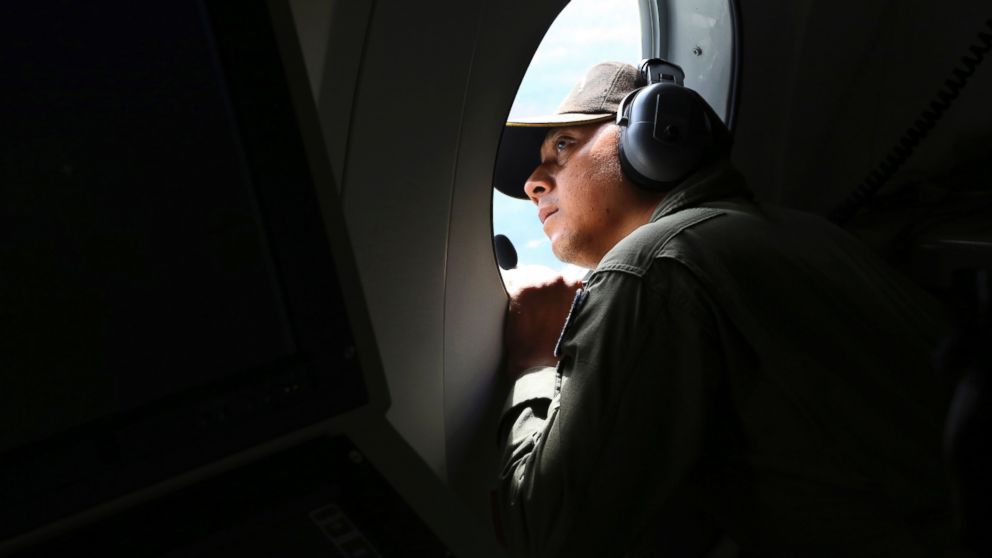 PHOTO: A crew member of Indonesian Navy CN-235 airplane looks out of the window during a search operation for the missing AirAsia flight 8501 over the waters off Bangka Island, Indonesia, Dec. 30, 2014.
