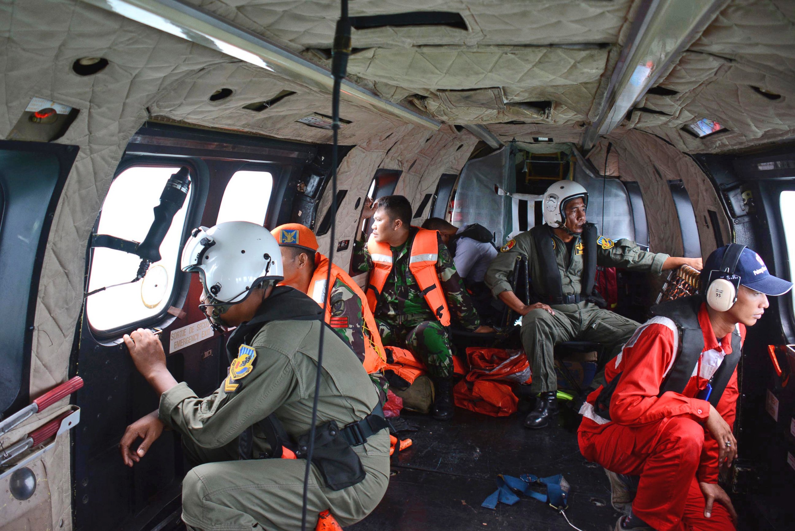PHOTO: Crew members of an Indonesian Air Force Super Puma helicopter of the 6th Air Squadron look out of the windows during a search operation for the victims of AirAsia Flight 8501 over Java Sea, Indonesia, Jan. 1, 2015.
