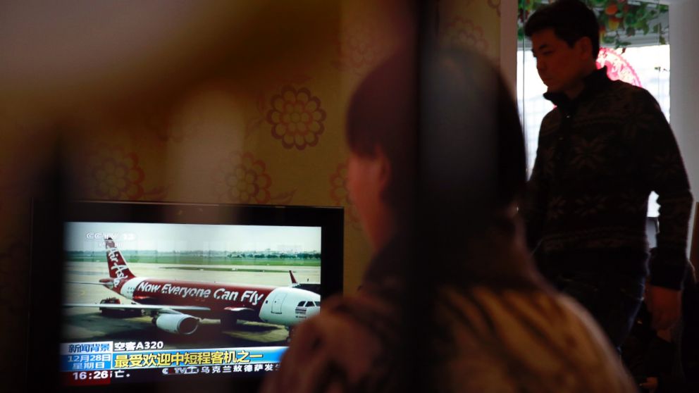 Relatives of passengers onboard the Malaysia Airlines Flight 370 that went missing on March 8, 2014, watch TV news about missing AirAsia flight QZ8501, during their year-end gathering at a house in Beijing, China Sunday, Dec. 28, 2014. 