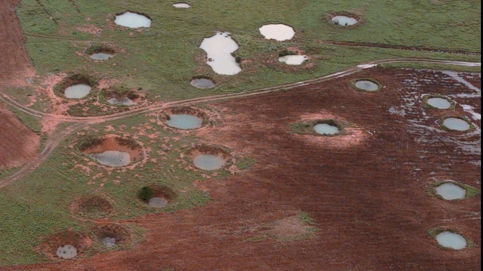 PHOTO: What appears to be ponds are actually water-filled bomb craters from the Vietnam War era, as seen from a helicopter, May 25, 1997, near the northeastern Laotian village of Sam Neau. 
