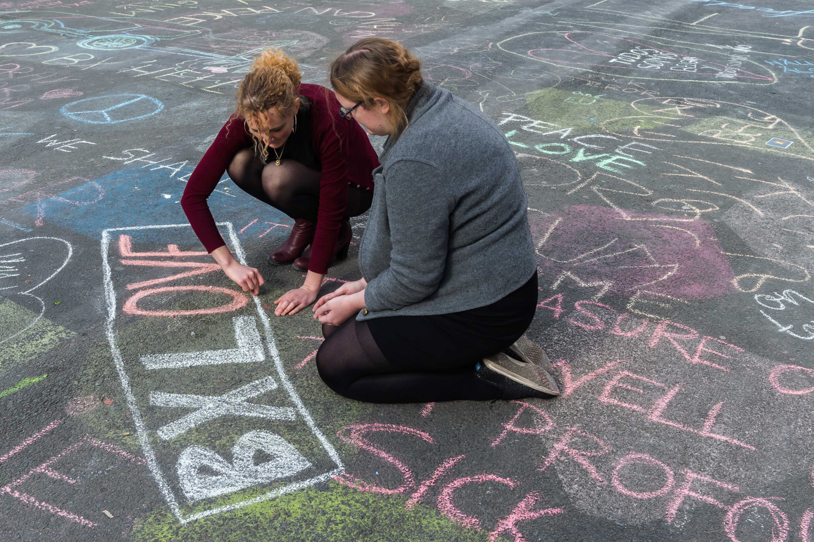 PHOTO: Two people write solidarity messages in chalk outside the stock exchange in Brussels, March 22, 2016. 