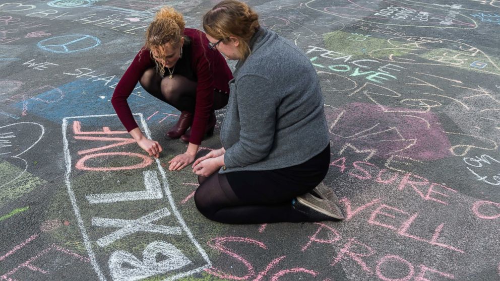 PHOTO: Two people write solidarity messages in chalk outside the stock exchange in Brussels, March 22, 2016. 
