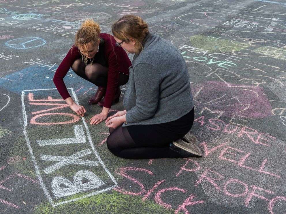 PHOTO: Two people write solidarity messages in chalk outside the stock exchange in Brussels, March 22, 2016.