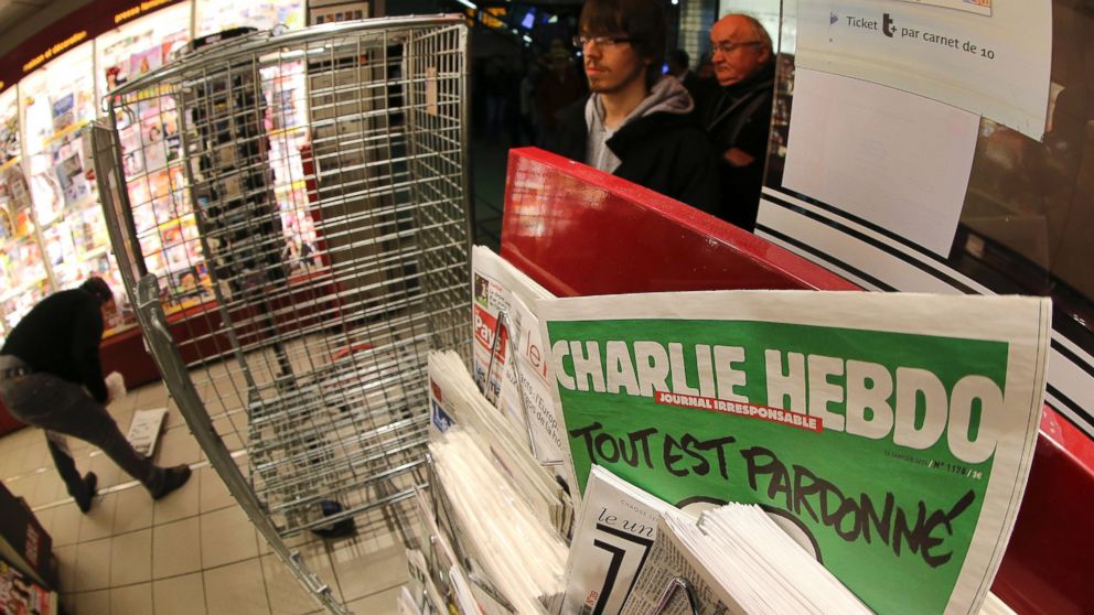 PHOTO: In this photo made with a fish-eye lens, people wait to buy the latest issue of Charlie Hebdo newspaper at a newsstand in Rennes, western France, Jan. 14, 2015.