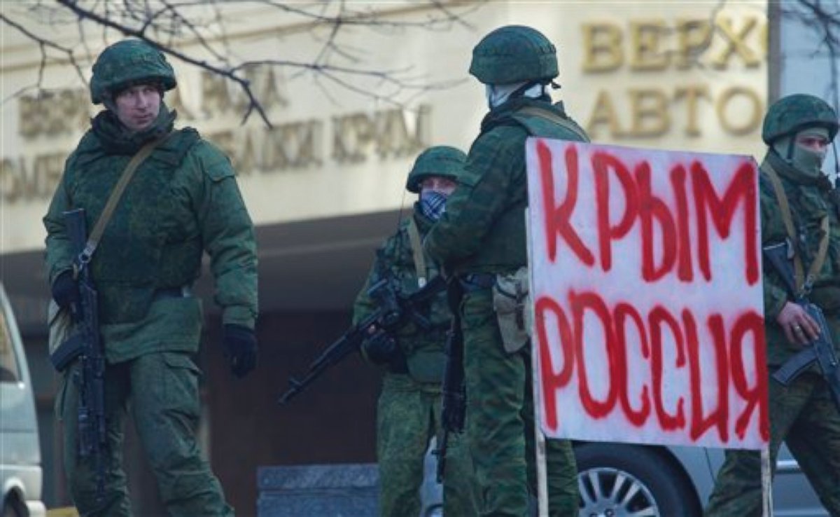 PHOTO: Unidentified gunmen wearing camouflage uniforms block the entrance of the Crimean Parliament building in Simferopol, Ukraine, Saturday, March 1, 2014. Poster reads "Crimea Russia".