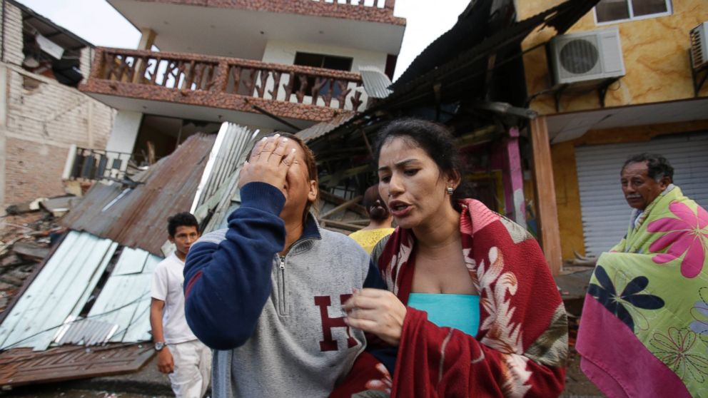 A woman cries as she stands next to house destroyed by the earthquake in the Pacific coastal town of Pedernales, Ecuador, Sunday, April 17, 2016.