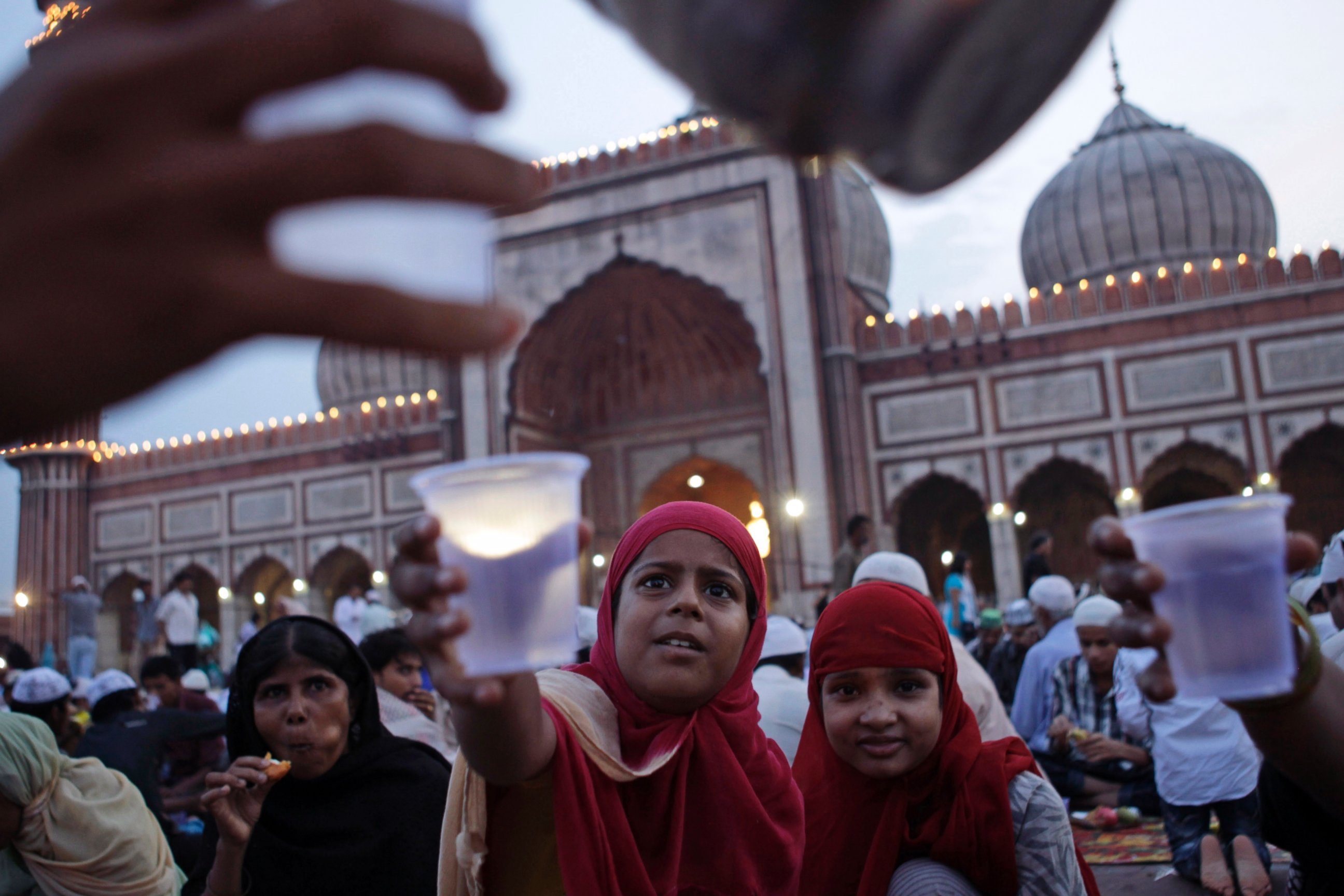 PHOTO: Muslim girls stretch their hands out to receive water after breaking fast at Jama Masjid ahead of Eid al-Fitr in New Delhi, Aug 8, 2013. Eid al-Fitr marks the end of the holy month of Ramadan, during which Muslims fast from sunrise to sunset. 