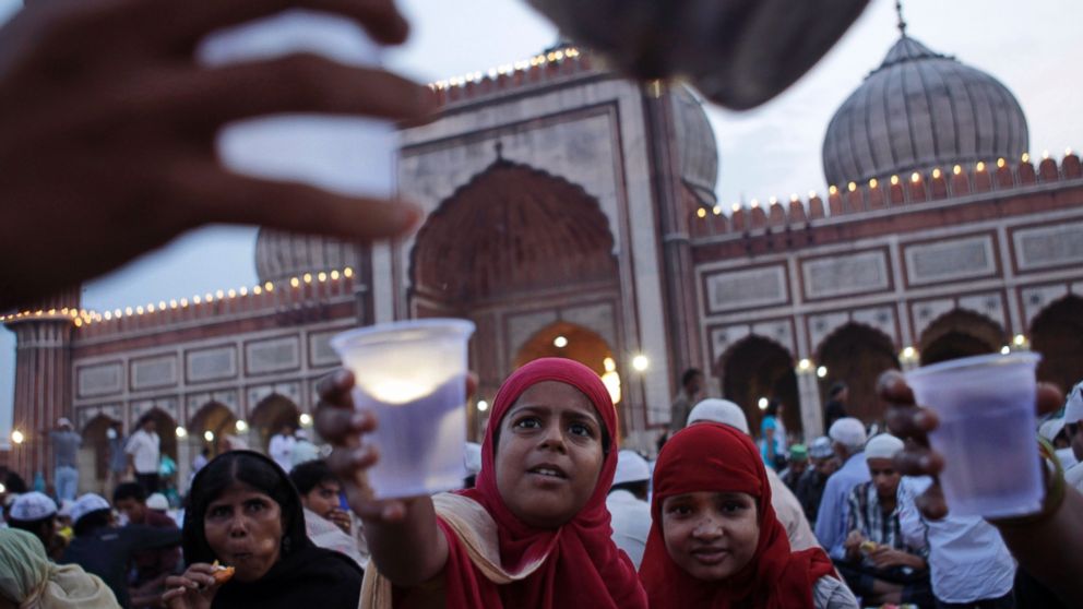 PHOTO: Muslim girls stretch their hands out to receive water after breaking fast at Jama Masjid ahead of Eid al-Fitr in New Delhi, Aug 8, 2013. Eid al-Fitr marks the end of the holy month of Ramadan, during which Muslims fast from sunrise to sunset. 
