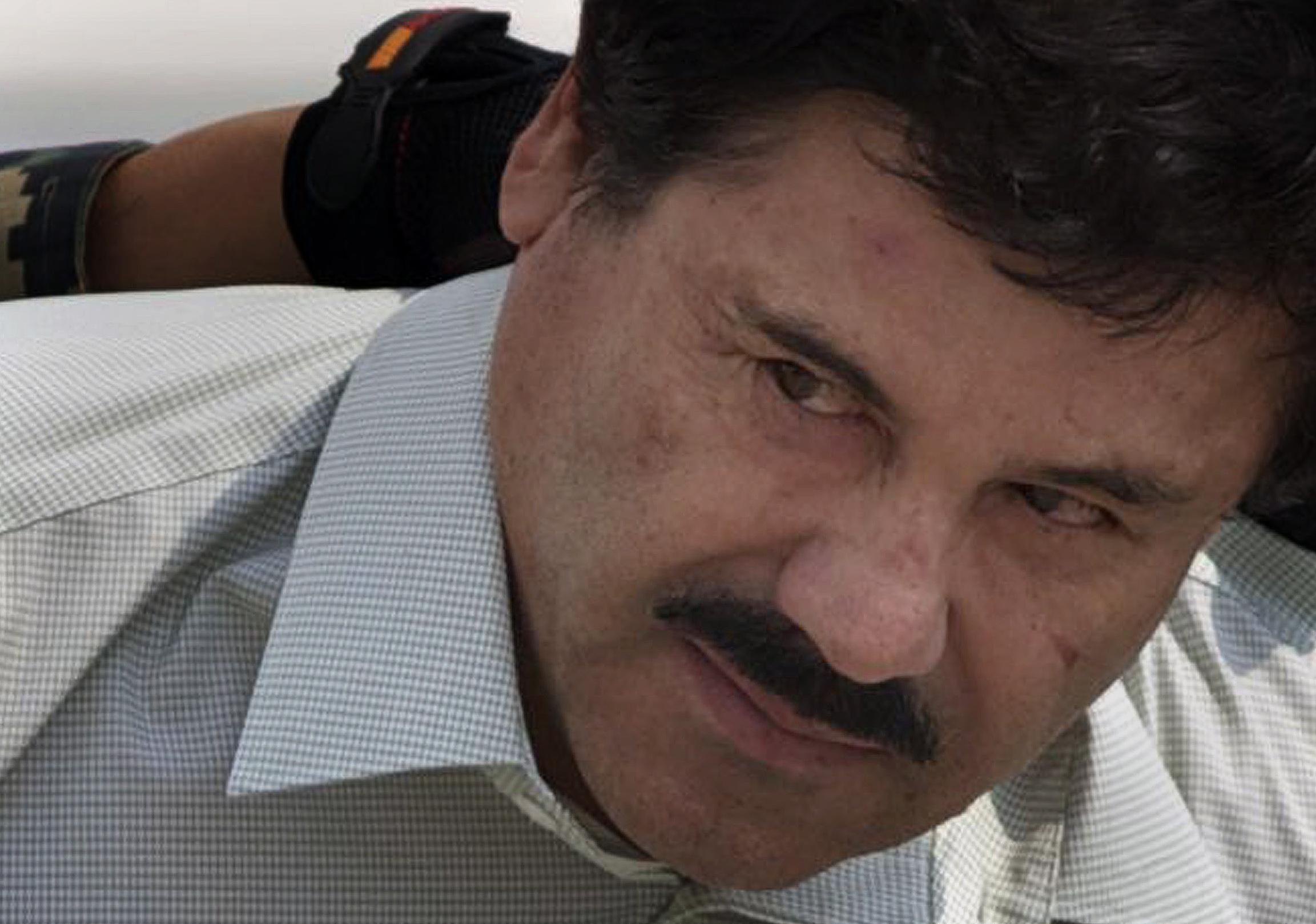 PHOTO: In this Feb. 22, 2014 photo, Joaquin "El Chapo" Guzman is escorted to a helicopter in handcuffs by Mexican navy marines at a navy hanger in Mexico City. 