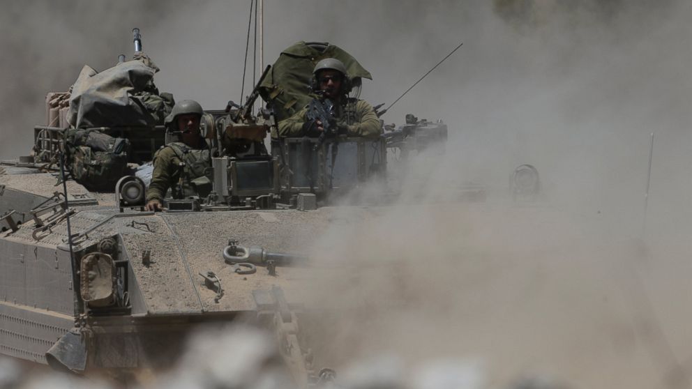 Israeli reserve soldiers are seen on the top of an armored personnel carrier returning to Israel from Gaza Strip, southern Israel, Aug. 4, 2014.