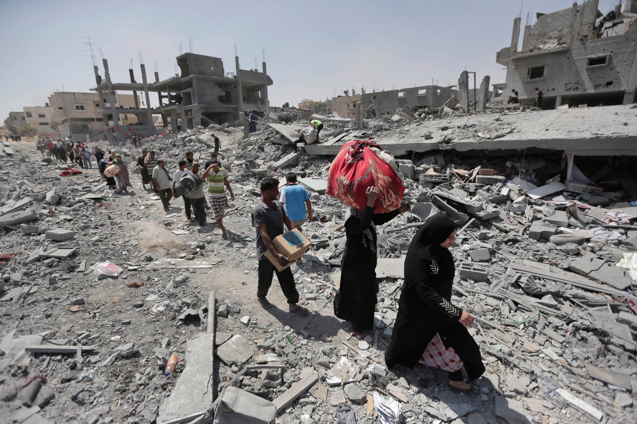 PHOTO: Palestinians carry their belongings after salvaging them from their destroyed houses in the town of Beit Hanoun, Gaza Strip, Aug. 1, 2014.