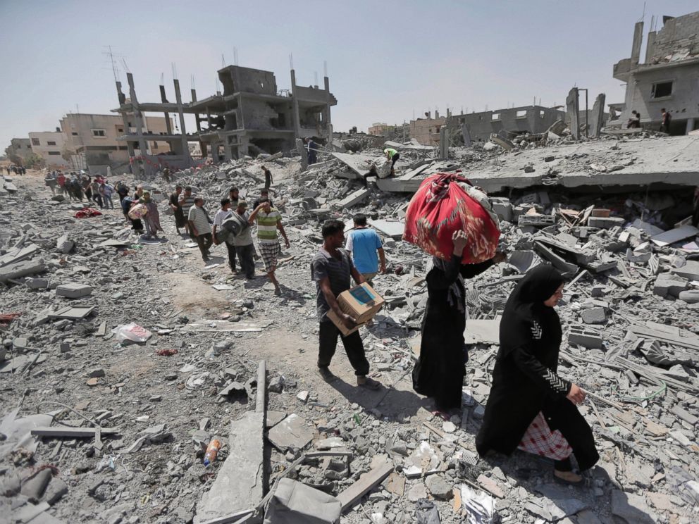 PHOTO: Palestinians carry their belongings after salvaging them from their destroyed houses in the town of Beit Hanoun, Gaza Strip, Aug. 1, 2014.