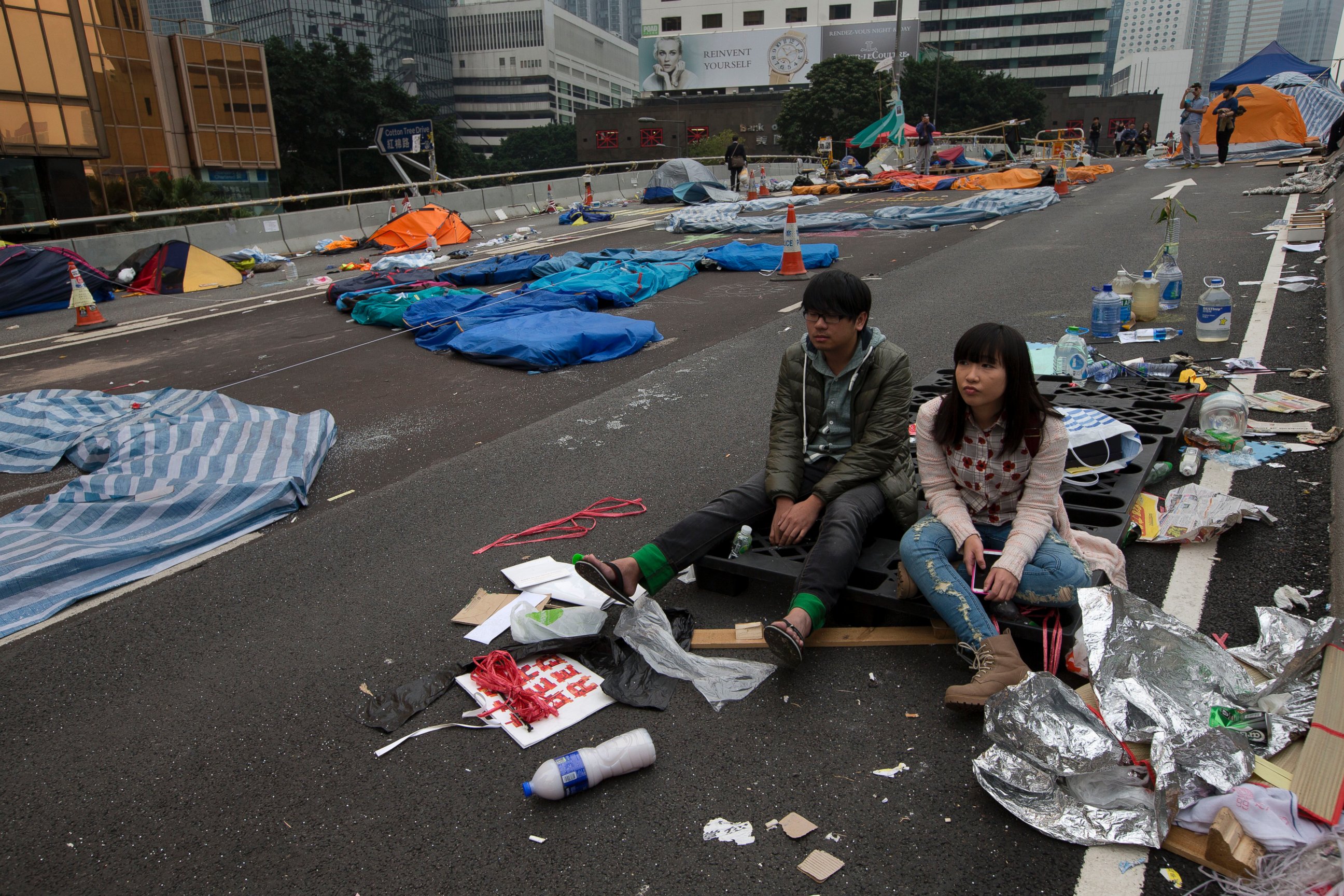 PHOTO: A couple sit at a main road before police clearing barricades and tents outside government headquarters in Hong Kong, Dec. 11, 2014.