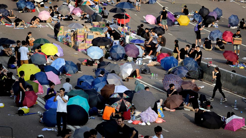 Student activists sleep on a road, many under the shade of umbrellas, near the government headquarters where pro-democracy activists have gathered and made camp, Sept. 30, 2014, in Hong Kong.