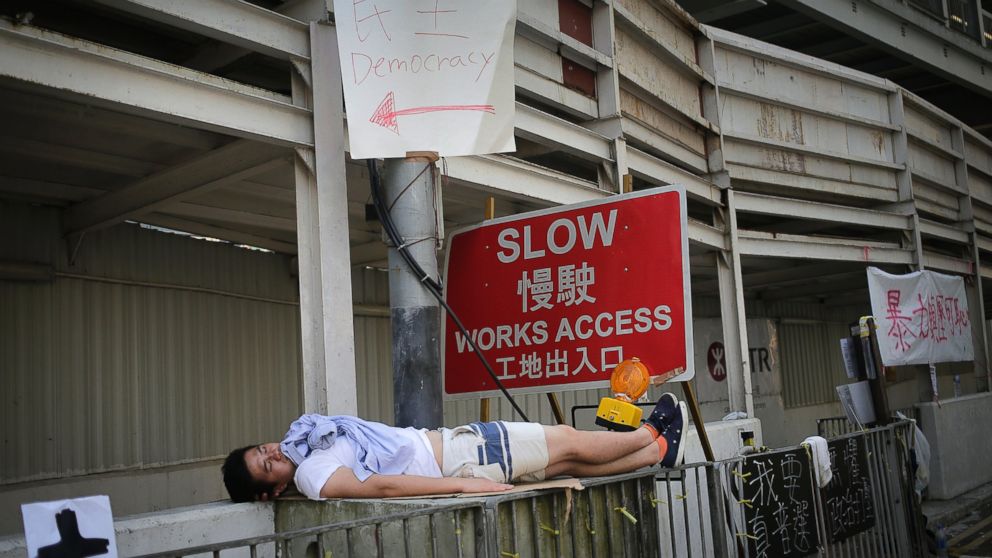 PHOTO: A pro-democracy activist sleeps on the sidewalk after an overnight protest, Sept. 30, 2014, in Hong Kong.