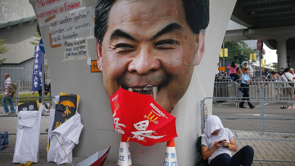 PHOTO: A student protester rests next to a defaced cut-out of Hong Kong's Chief Executive Leung Chun-ying at one of their protest sites around the government headquarters, Sept. 30, 2014, in Hong Kong.