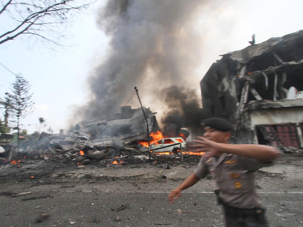 PHOTO: A police officer gestures at the crowd near the site where an Air Force cargo plane crashed in Medan, North Sumatra, Indonesia, June 30, 2015.