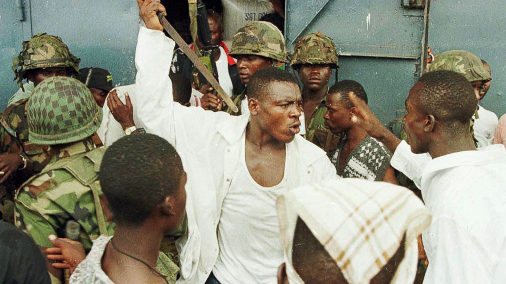 Joshua Milton Blahyi, a former Liberian factional fighter known as "General Butt Naked", threatens a fellow combatant with a knife during an argument outside the Barclay Training Center army barracks in Monrovia, Liberia, May 15, 1996.