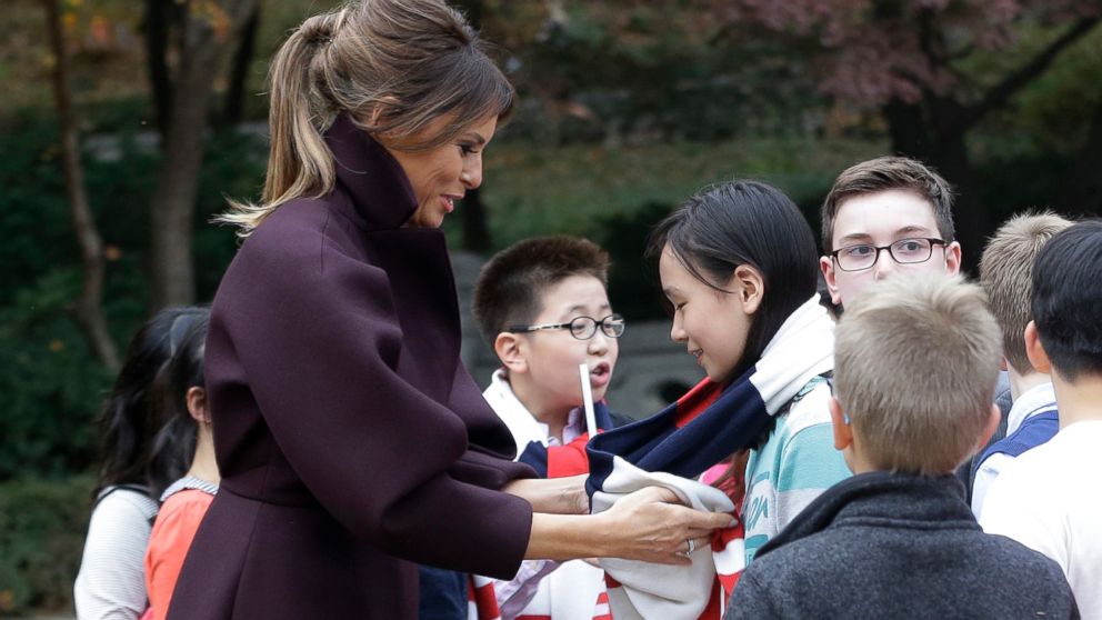 U.S. first lady Melania Trump puts on a scarf to a South Korean girl at the presidential Blue House in Seoul, South Korea, Tuesday, Nov. 7, 2017.