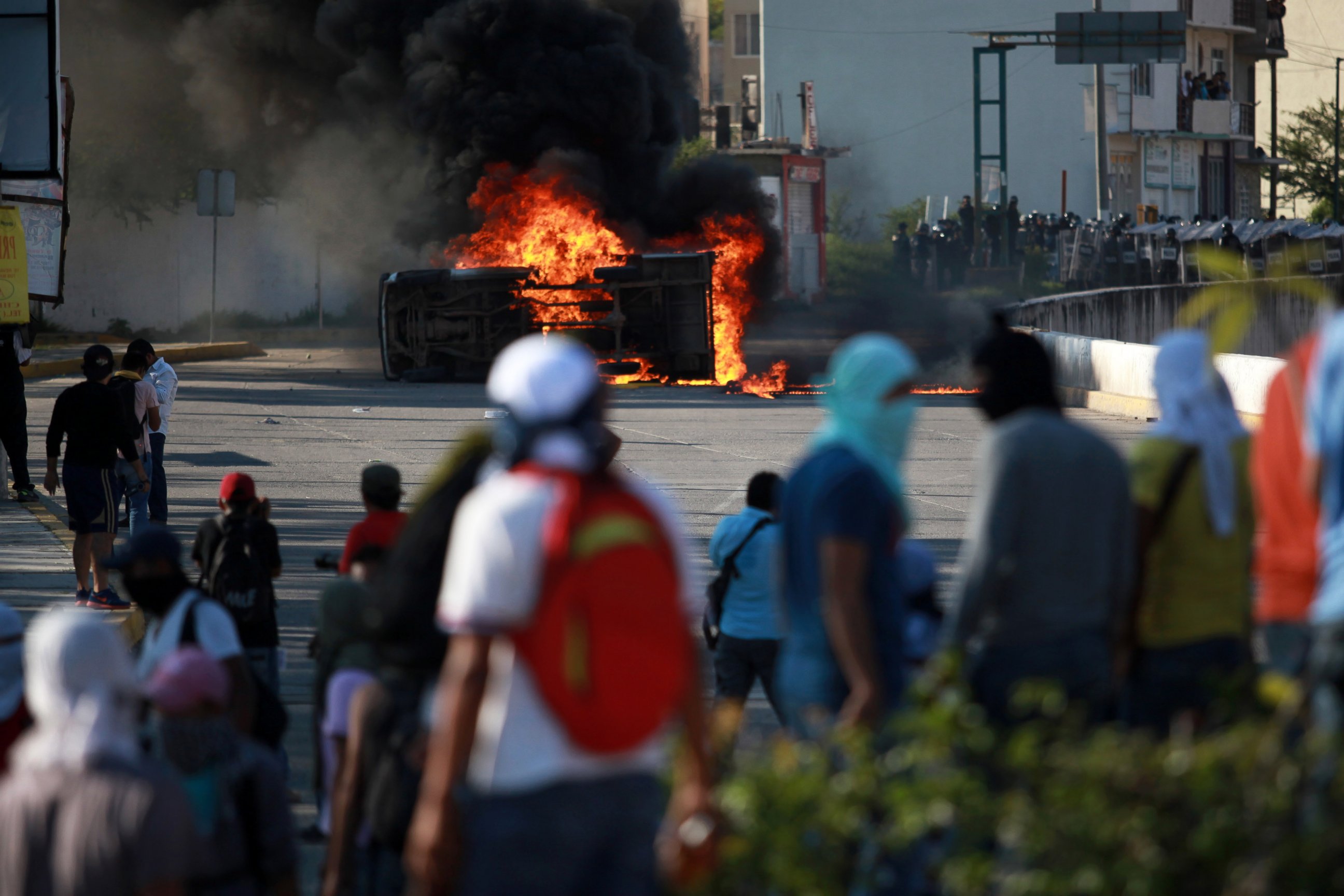 PHOTO: A burning overturned car stands between protesting students and riot police after it was set on fire by protesting college students outside of the Guerrero state capital building in Chilpancingo, Mexico, Oct. 13, 2014.
