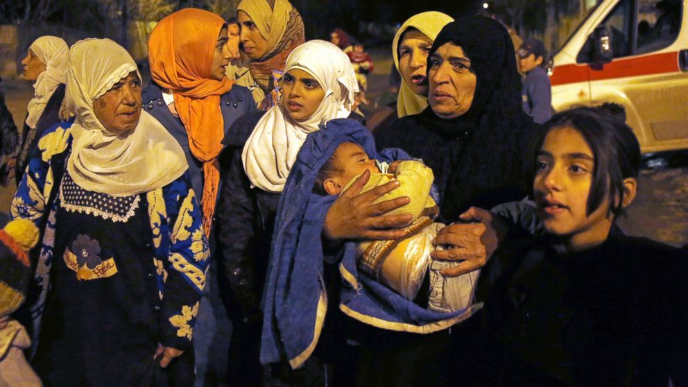 In this Jan. 11, 2016 photo, people wait to leave the besieged town of Madaya, northwest of Damascus, Syria. Aid convoys reached three besieged villages, where U.N. humanitarian chief Stephen O'Brien said about 400 people needed to be evacuated immediately to receive life-saving treatment for medical conditions, malnourishment and starvation, and the Shiite villages of Foua and Kfarya in northern Syria. Reports of starvation and images of emaciated children have raised global concerns and underscored the urgency for new peace talks that the U.N. is hoping to host in Geneva on Jan. 25. 