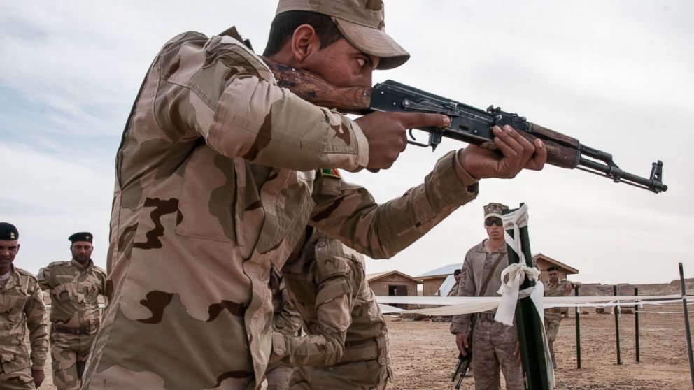 In this photo an Iraqi army trainee rehearses proper room clearing techniques under the supervision of a U.S. Marine during training, as part of their commitment in helping combat the Islamic State militant group in Iraq, at Al-Asad Air Base in Anbar province, Feb. 10, 2015. 