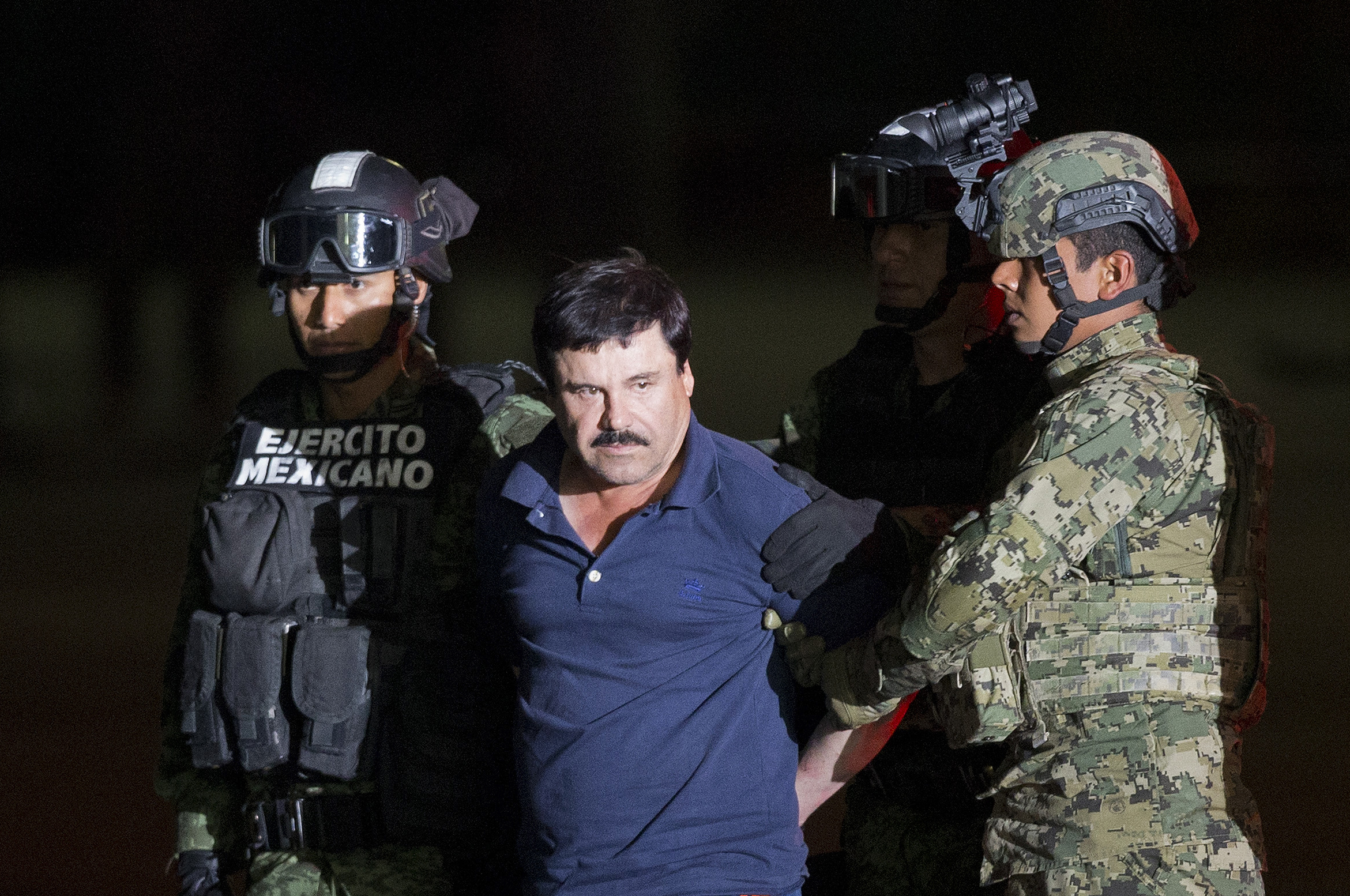 PHOTO: Joaquin "El Chapo" Guzman is made to face the press as he is escorted to a helicopter in handcuffs by Mexican soldiers and marines at a federal hangar in Mexico City, Mexico, Friday, Jan. 8, 2016.