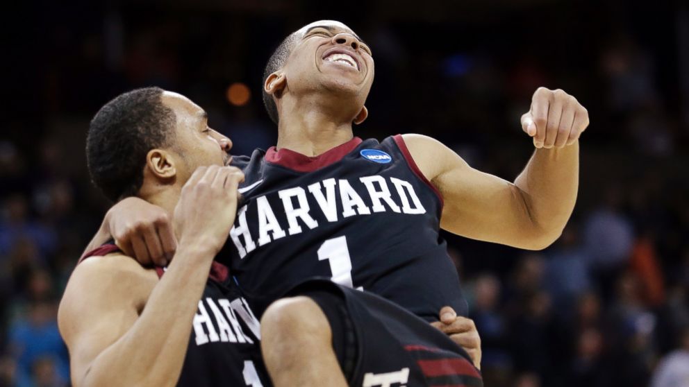 Harvard's Siyani Chambers, right, leaps into the arms of teammate Brandyn Curry after the team beat Cincinnati in the second round of the NCAA college basketball tournament in Spokane, Wash., March 20, 2014. Harvard won 61-57. 