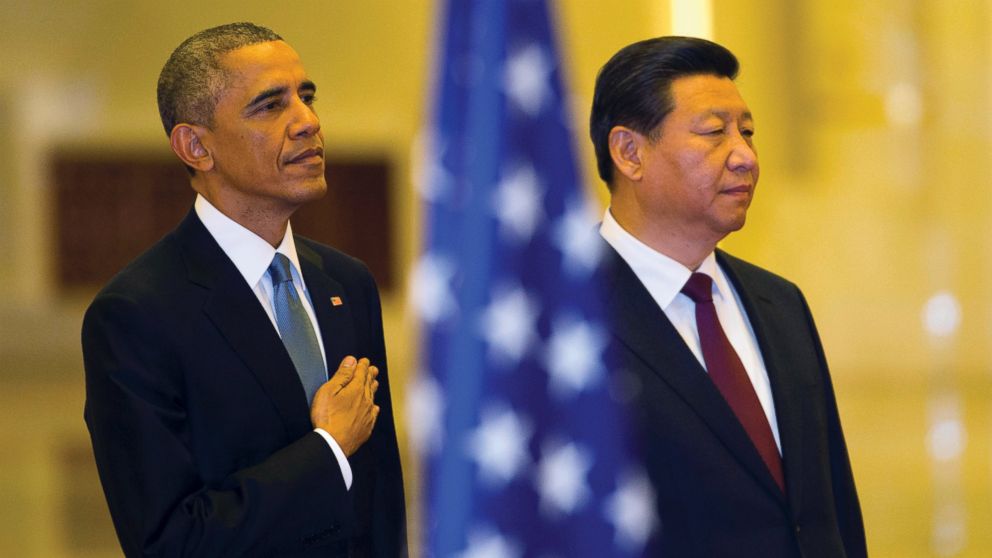 U.S. President Barack Obama places his hand on his chest as the U.S. national anthem is played at a welcome ceremony with Chinese President Xi Jinping inside the Great Hall of the People in Beijing, Nov. 12, 2014.