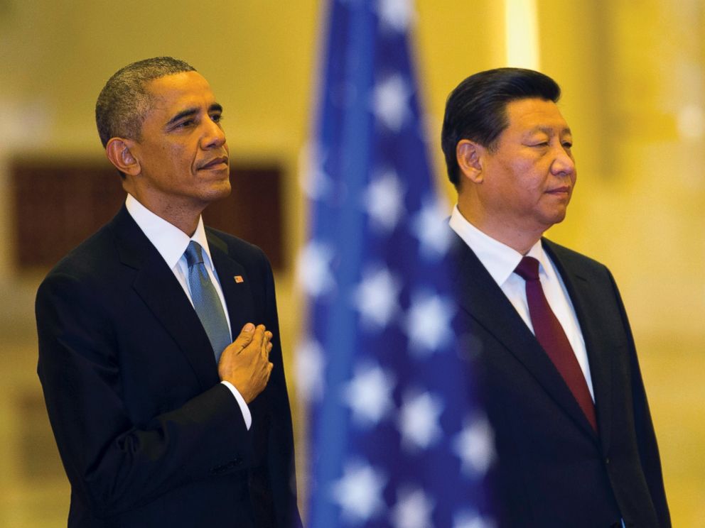 U.S. President Barack Obama places his hand on his chest as the U.S. national anthem is played at a welcome ceremony with Chinese President Xi Jinping inside the Great Hall of the People in Beijing, Nov. 12, 2014.