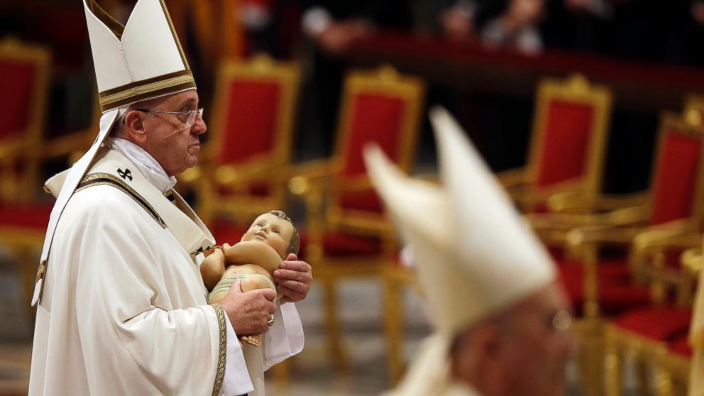 Pope Francis carries a statue of Baby Jesus at the end of the Christmas Eve Mass in St. Peter's Basilica at the Vatican, Dec. 24, 2014.
