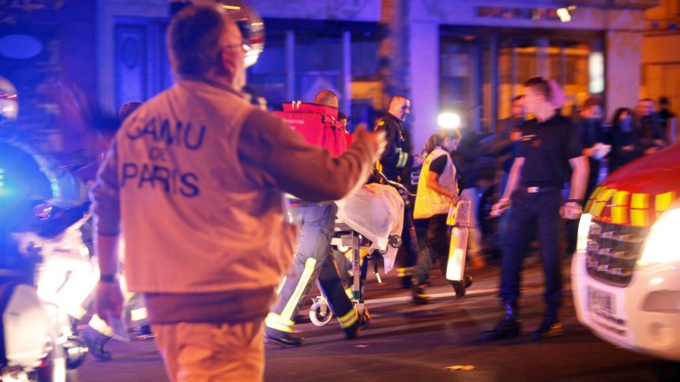 Person are being evacuated after a shooting, outside the Bataclan theater in Paris, Saturday, Nov. 14, 2015.  A series of attacks targeting young concert-goers, soccer fans and Parisians enjoying a Friday night out at popular nightspots killed over 1000 people in the deadliest violence to strike France since World War II.