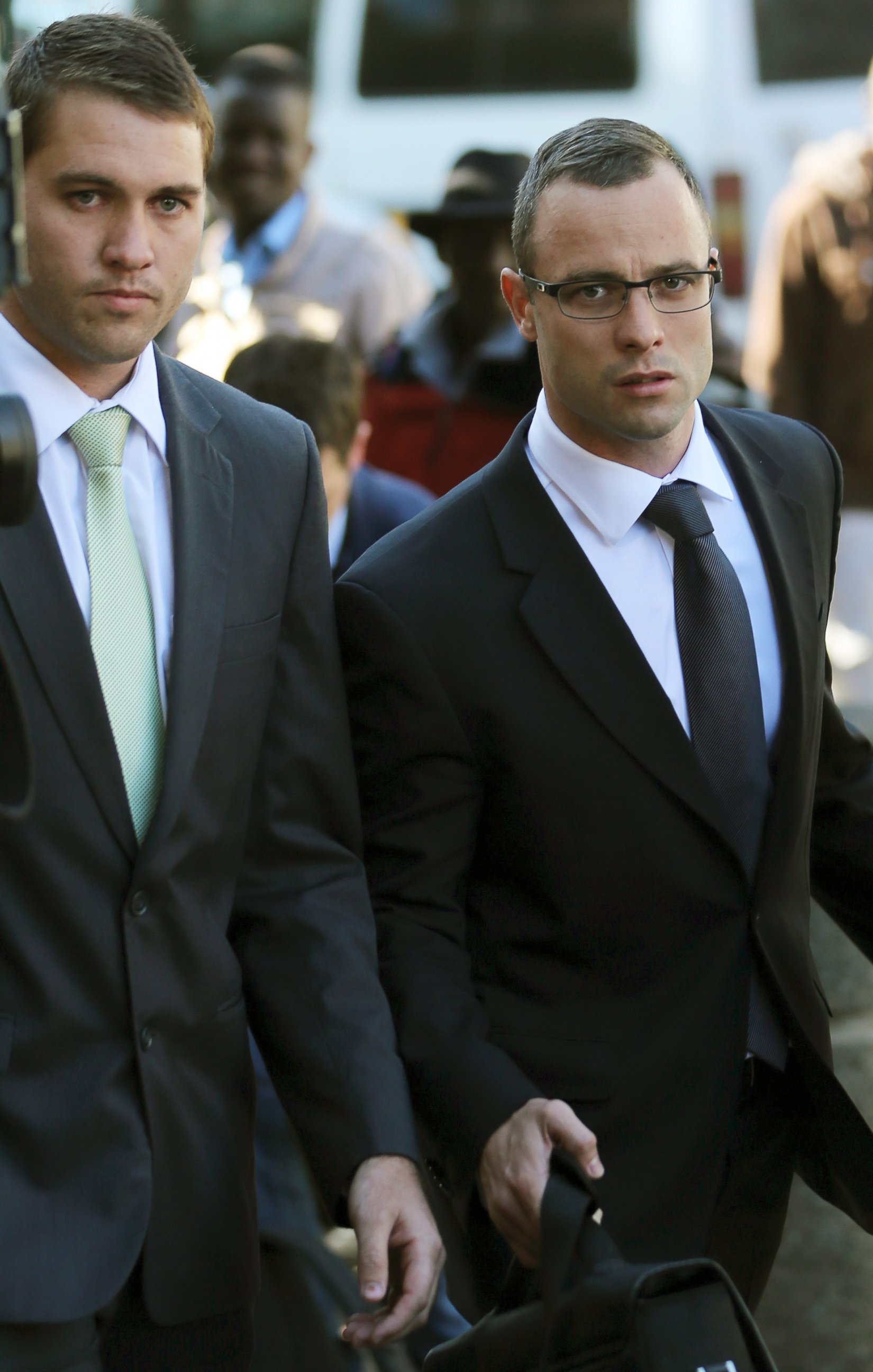 PHOTO: Oscar Pistorius, right, walks outside the high court in Pretoria, South Africa, May 14, 2014.