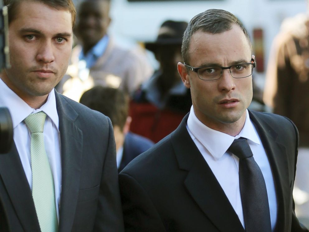 PHOTO: Oscar Pistorius, right, walks outside the high court in Pretoria, South Africa, May 14, 2014.