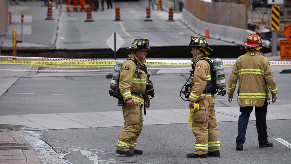 PHOTO: Firefighters at the scene of a large sinkhole that formed on Rideau Street, June 8, 2016 in Ottawa. A van fell into the sinkhole but there are no reports of injuries.