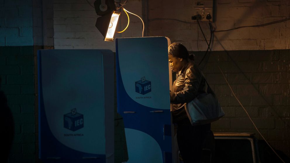 A woman casts her vote at a polling station illuminated by floodlight in Soweto, South Africa, Aug. 3, 2016. South Africans are voting in municipal elections in which the ruling African National Congress seeks to retain control of key metropolitan areas despite a vigorous challenge from opposition parties.