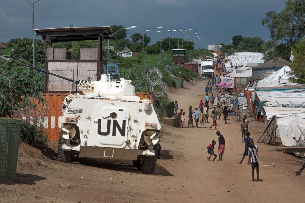 PHOTO: In this photo taken, July 25, 2016, more than 30,000 Nuer civilians sheltering in a United Nations base in South Sudan's capital Juba for fear of targeted killings by government forces walk by an armored vehicle manned by Chinese peacekeepers. 