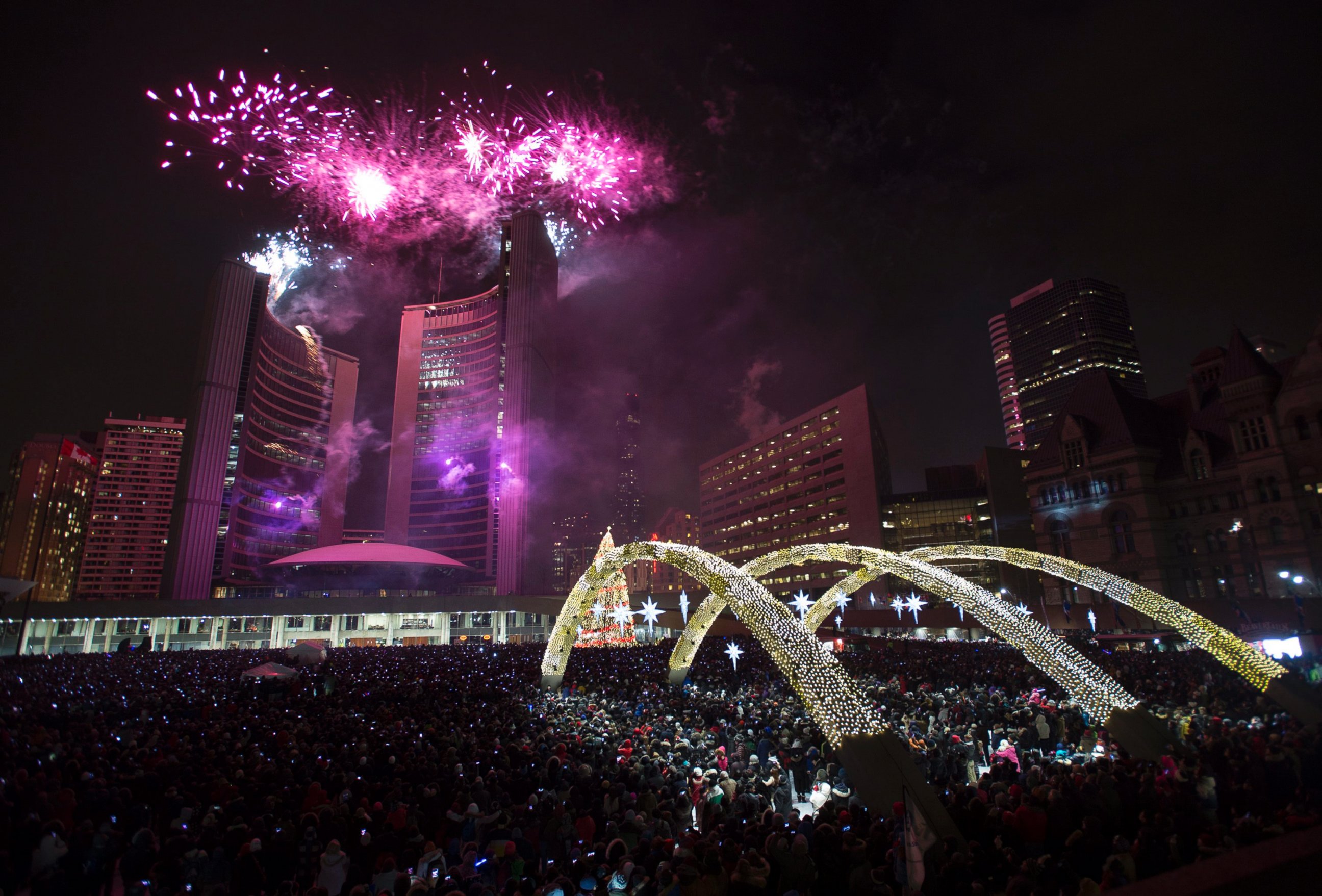 Fireworks explode in front of City Hall as revelers pack Nathan Phillips Square for New Year's celebrations in Toronto on Thursday, Jan. 1, 2015.